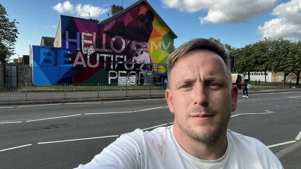 Nathan Murdoch in front of mural