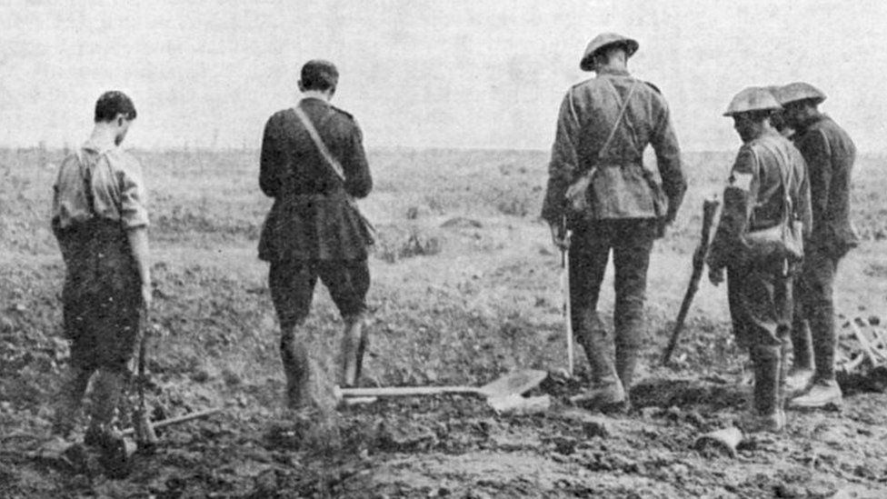 Army chaplain conducting burial service in the field, c.1916.