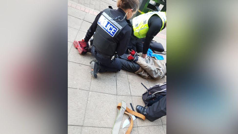 Man on the floor handcuffed by officers