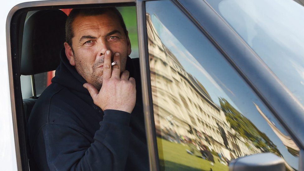 A man smokes while in a car