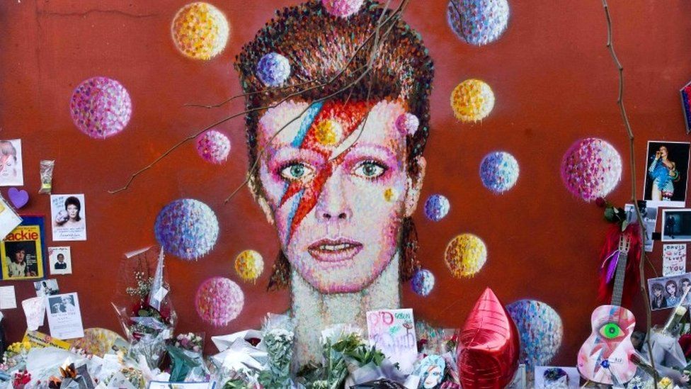Floral tributes placed in front of a mural of British singer David Bowie, painted by Australian street artist James Cochran, aka Jimmy C, in Brixton, south London.