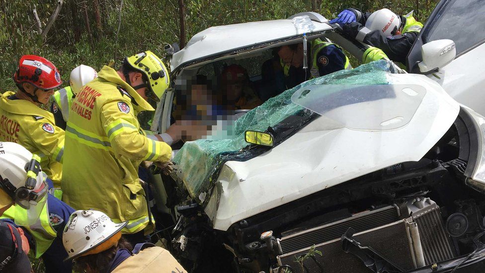 Rescuers work to free the man from the car wreckage