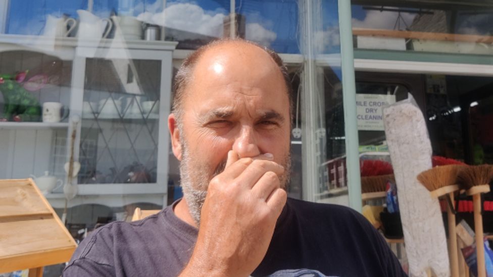 Wayne Duffy holding his nose outside a shop in Eye, Suffolk