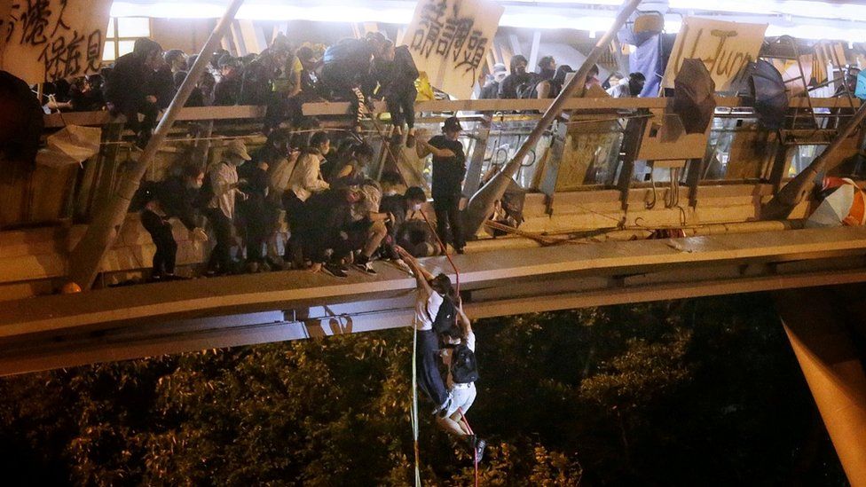 Protesters trapped inside Hong Kong Polytechnic University abseil onto a main road