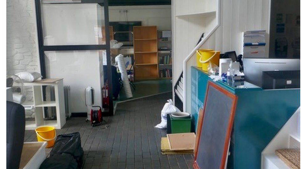Part of the library building showing buckets, heaters and items removed from the wall and shelves