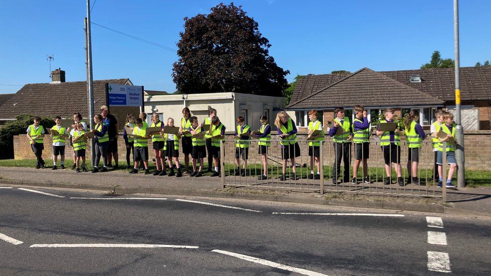 Horsford Primary School pupils gather on the roadside