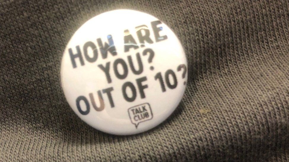 A small white pin badge with text 'how are You out of 10?'