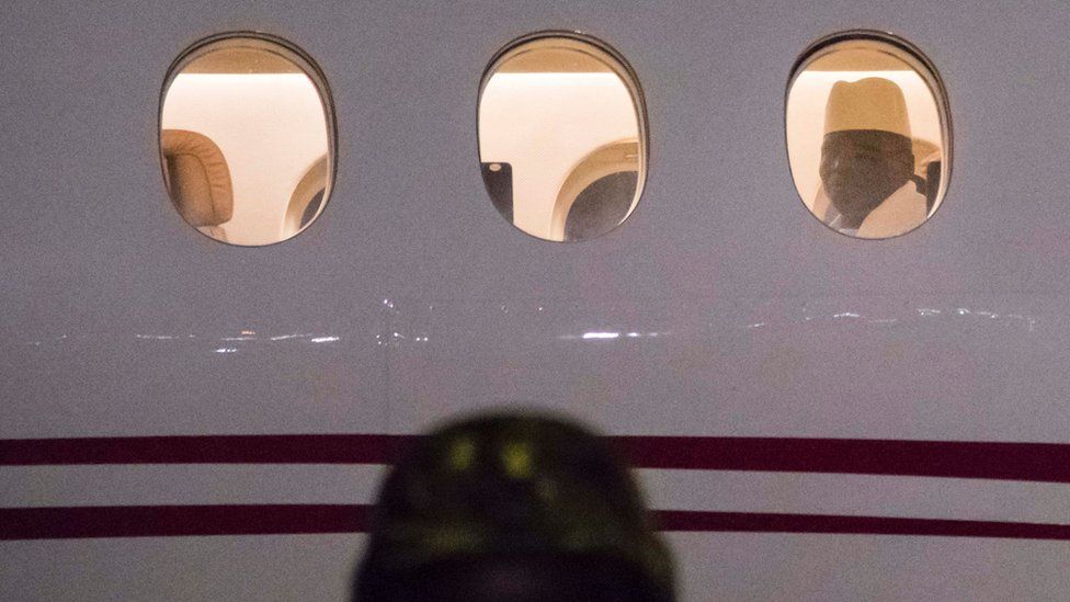 Former president Yaya Jammeh the Gambia's leader for 22 years, looks through the window from the plane as he leaves the country on 21 January 2017 in Banjul airpor