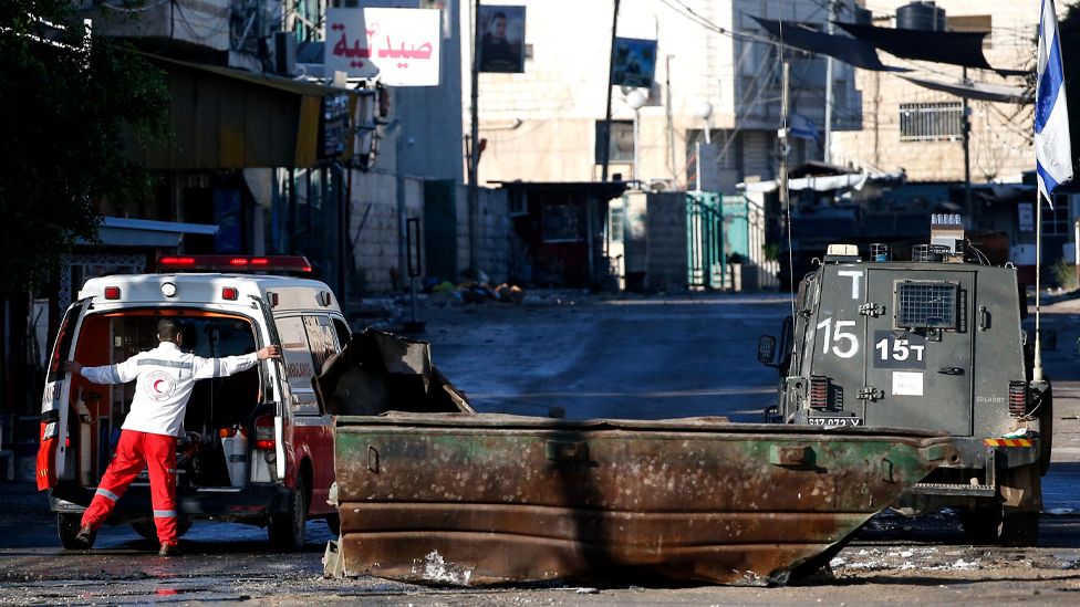 An ambulance trying to reach Jenin Hospital is stopped for search by the Israeli forces as their raid on Jenin refugee camp enters a third consecutive day, near the West Bank city of Jenin, 14 December 2023