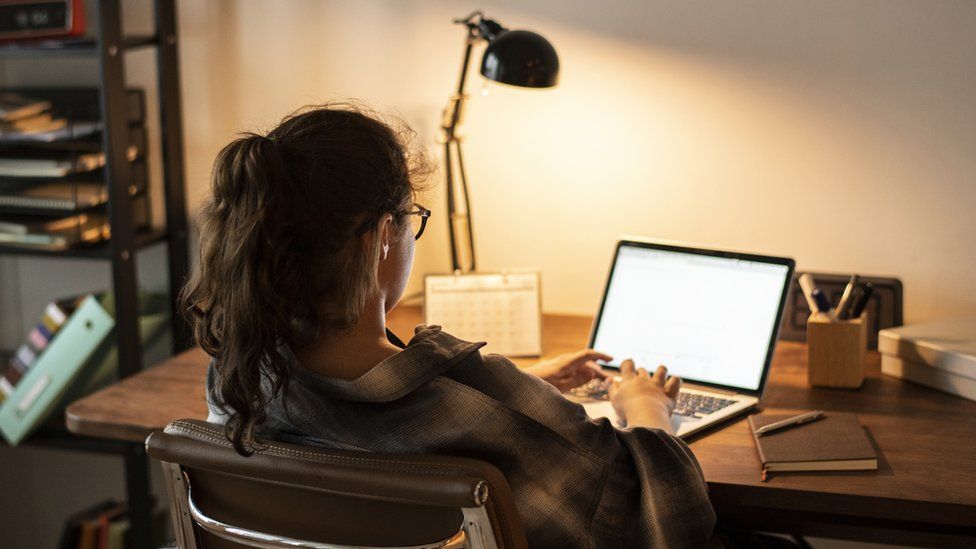 Woman works at laptop at night