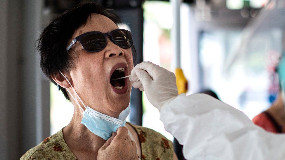 A medical worker takes samples during a mass Covid-19 test in Wuhan