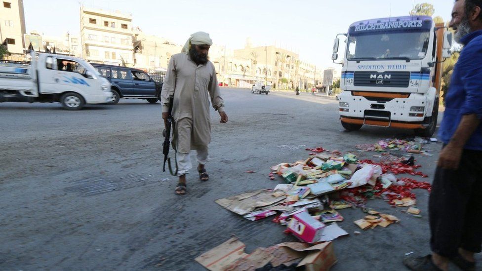 Islamic State fighter throws confiscated goods away in Raqqa, Syria (14 August 2014)