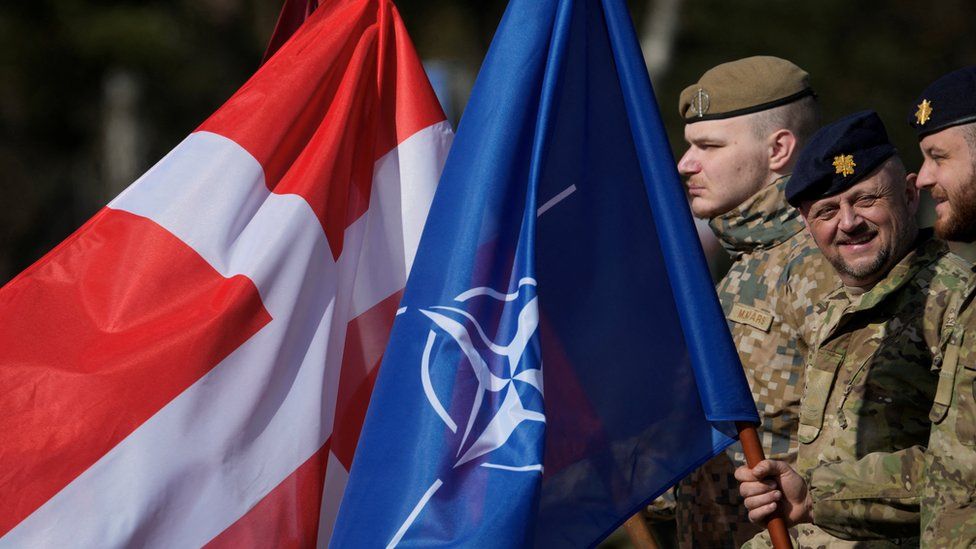 Danish troops hold Danish and Nato flags in Latvia March 31, 2022