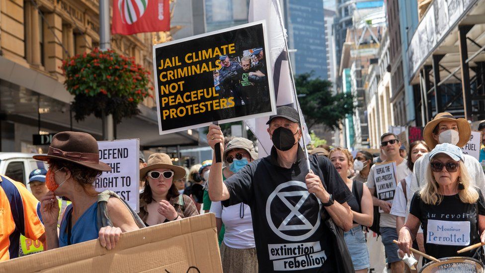 Protestors holding signs criticising the jailing of protestor Violet Coco