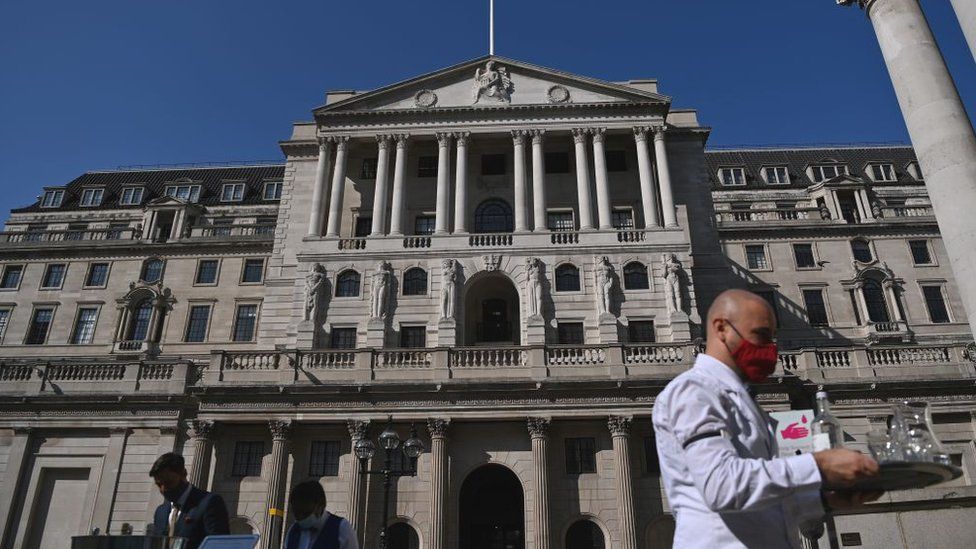 A waiter serves drinks outside of the Bank of England