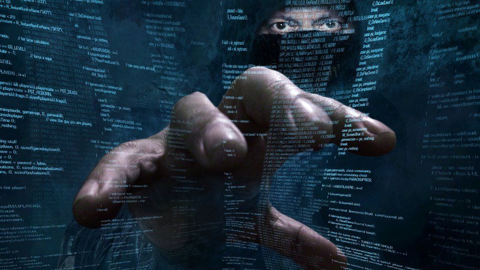 Hacker's hand reaching through screen of code