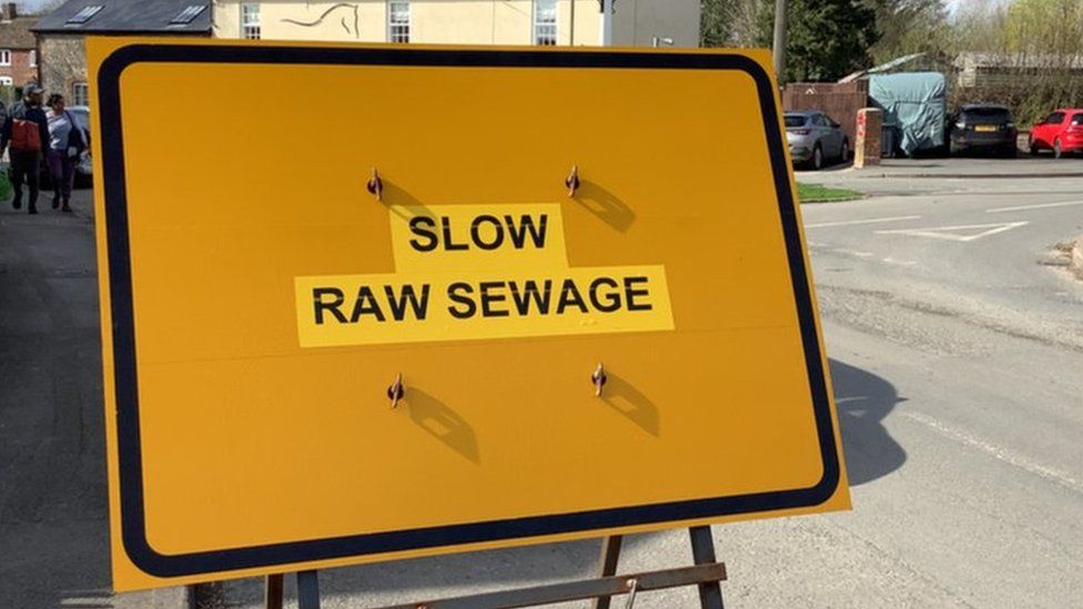 Sign that reads 'slow raw sewage'