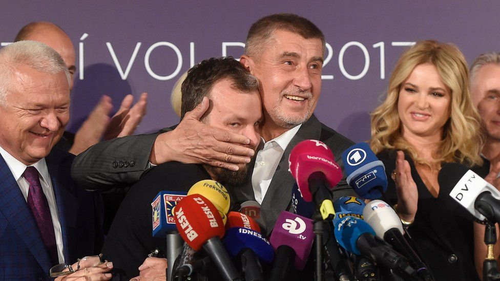Czech billionaire Andrej Babis (C,R), chairman of the ANO movement (YES) kisses Marek Prchal, PR manager of ANO for social media at ANO headquarter after Czech elections on October 21, 2017 in Prague.