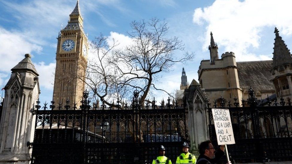 A man walks with a sign past police officers