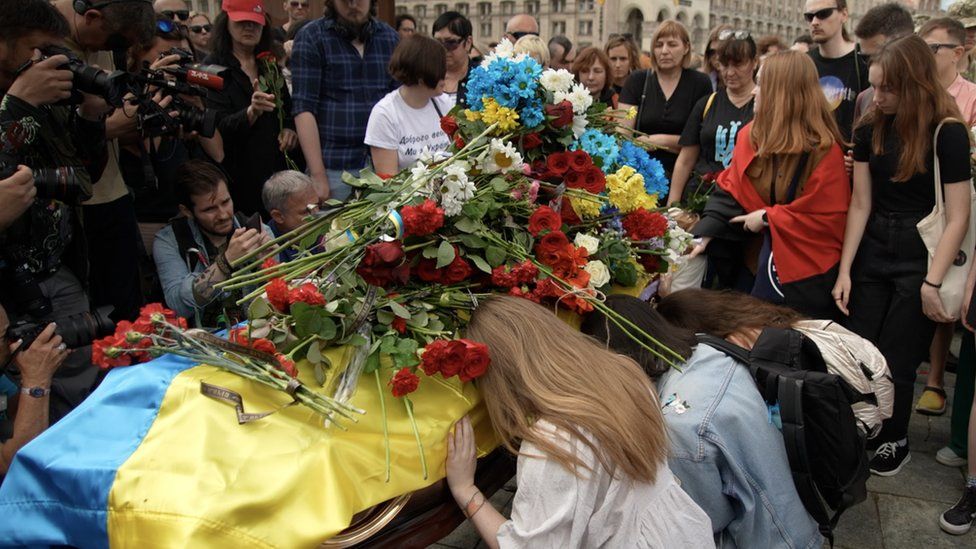 Mourners pay their respects and leave flowers on the coffin of Roman Ratushny in Independence Square