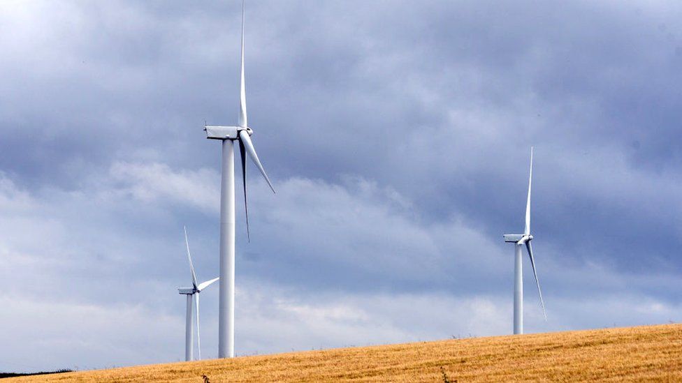 Wind turbines rise above a wheatfield in Fife