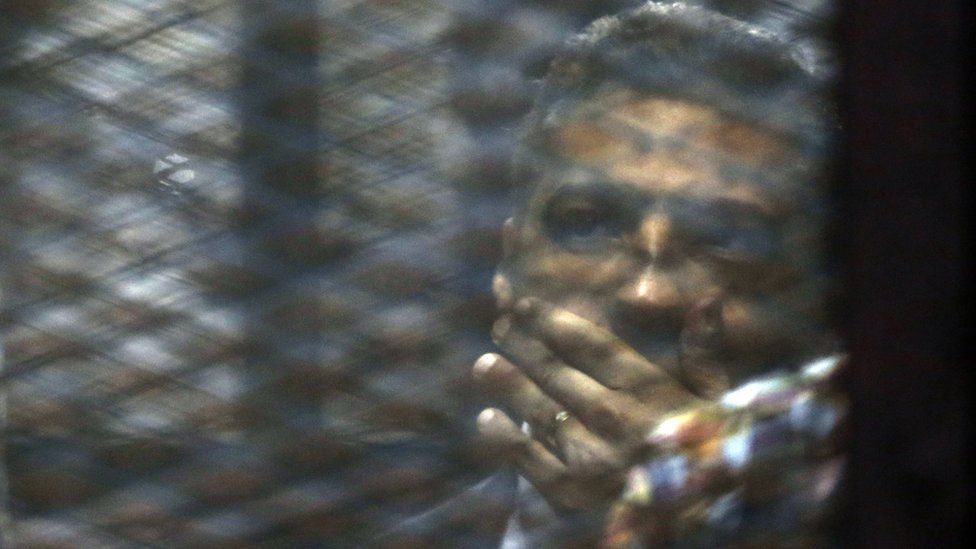 Canadian Al-Jazeera English journalist Mohammed Fahmy, listens to his verdict in a soundproof glass cage inside a makeshift courtroom in Tora prison in Cairo, Egypt, Saturday, Aug. 29, 2015.