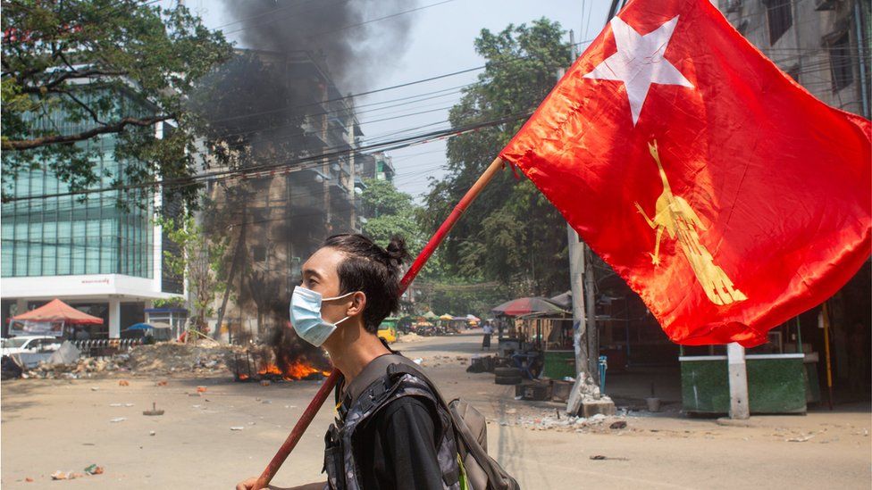 A man with a National League for Democracy flag in Yangon