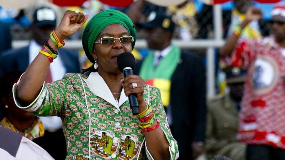 Grace Mugabe is pictured holding her hand in the air addressing a crowd