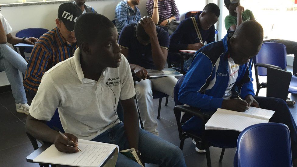 Migrants having an Italian lesson in a classroom