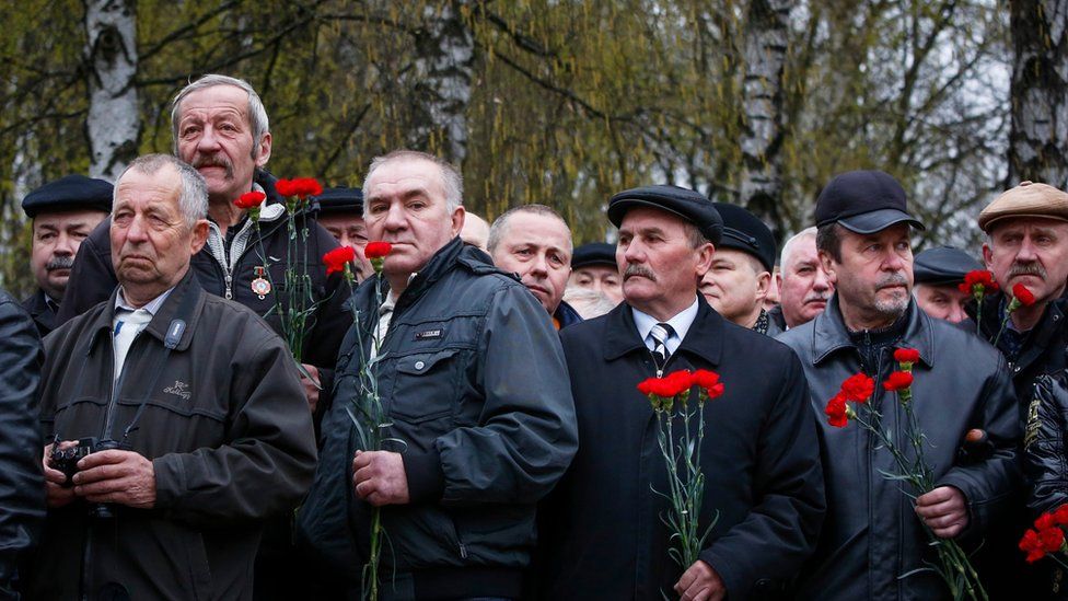 Belarusian veterans of the clear up operation hold red flowers as they gather to remember the disaster, in Minsk, Belarus, on 26 April 2016