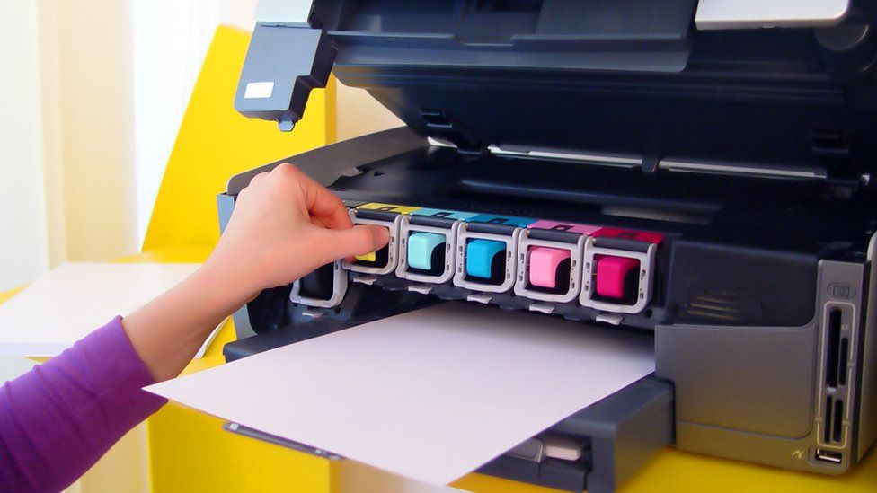 Человек, ремонтирующий картридж для принтера