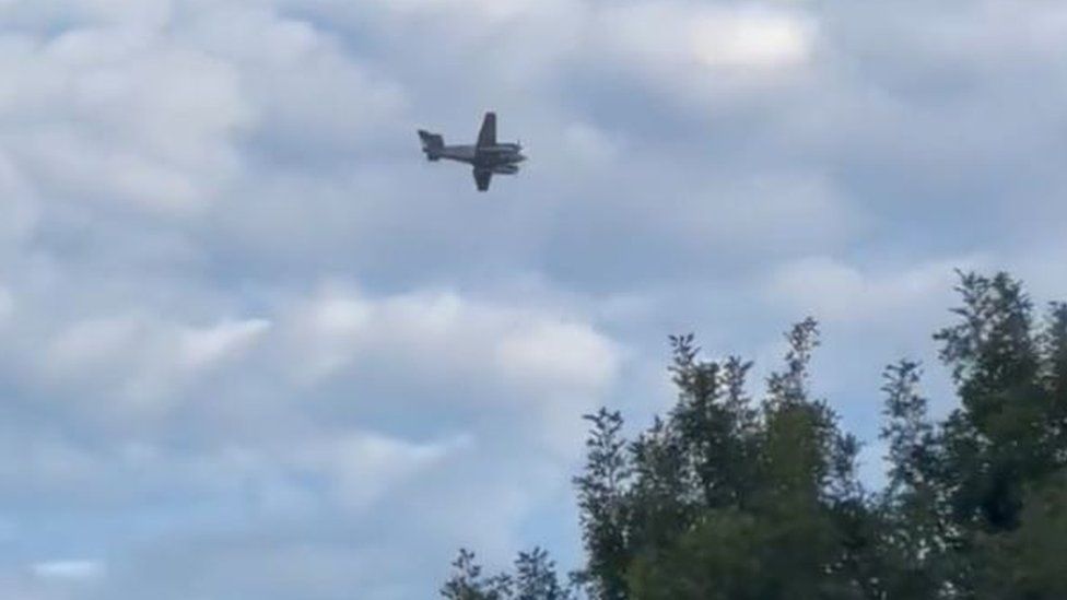 Social media footage a small plane in the air above the city