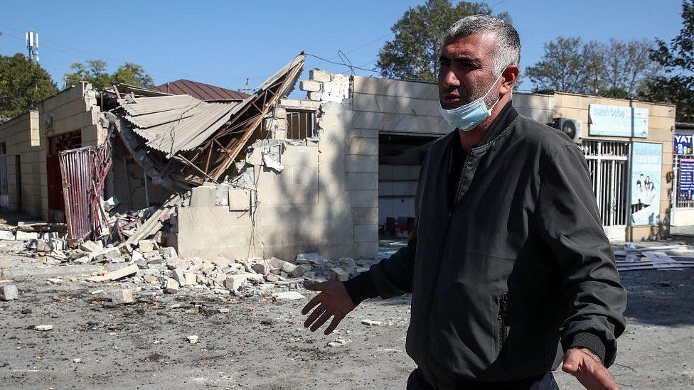 A man walks by a market in Tartar, Azerbaijan, damaged in a shelling attack