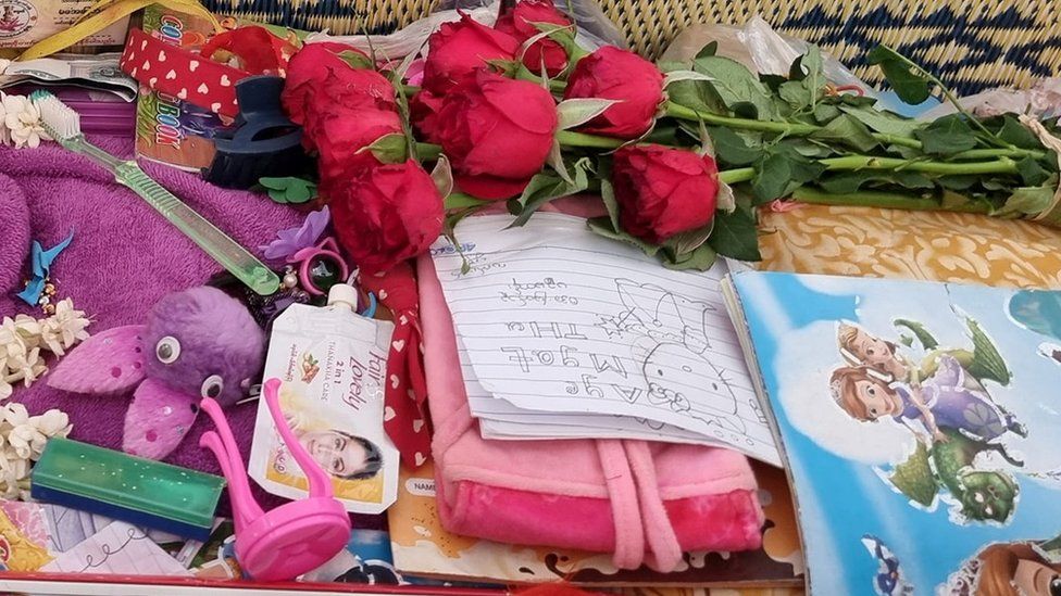 Toys flowers and drawings are seen in Aye Myat Thu's coffin