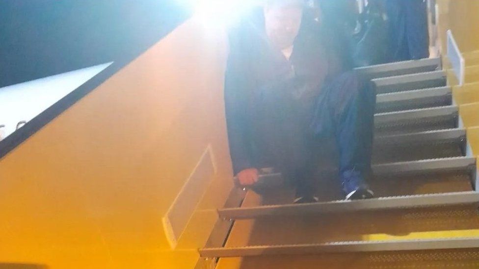 Adrian Keogh crawling down aircraft steps
