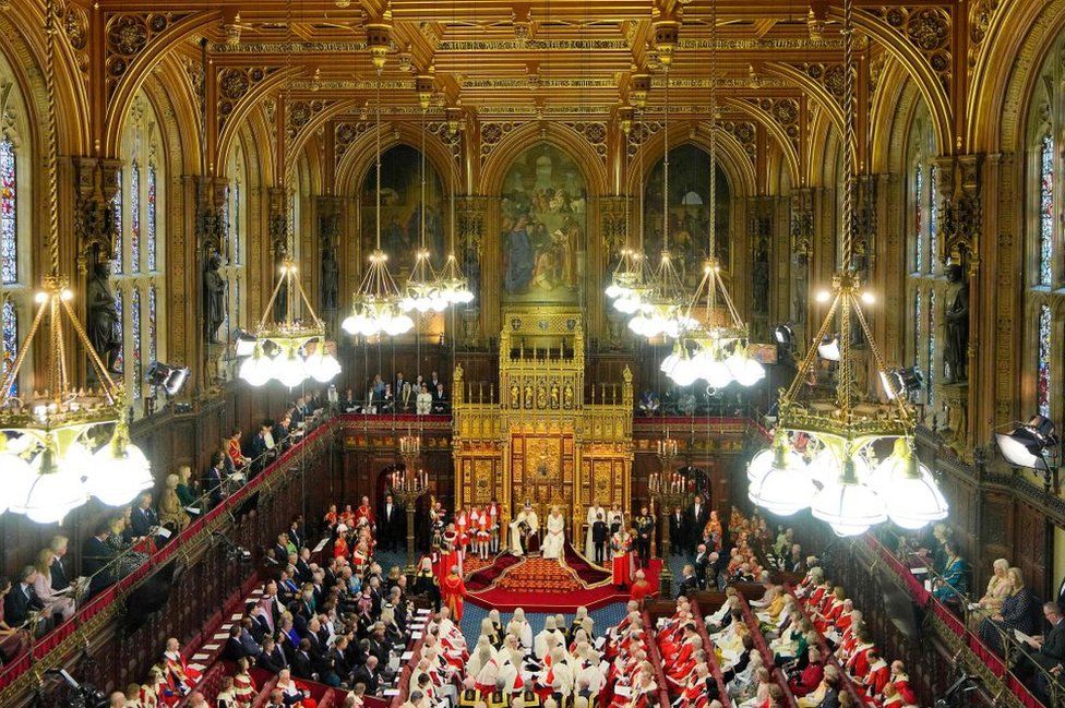 Britain's King Charles III, wearing the Imperial State Crown and the Robe of State, and Britain's Queen Camilla, wearing the George IV State Diadem, sits on The Sovereign's Throne in the House of Lords chamber, during the State Opening of Parliament, at the Houses of Parliament, in London, on November 7, 2023.