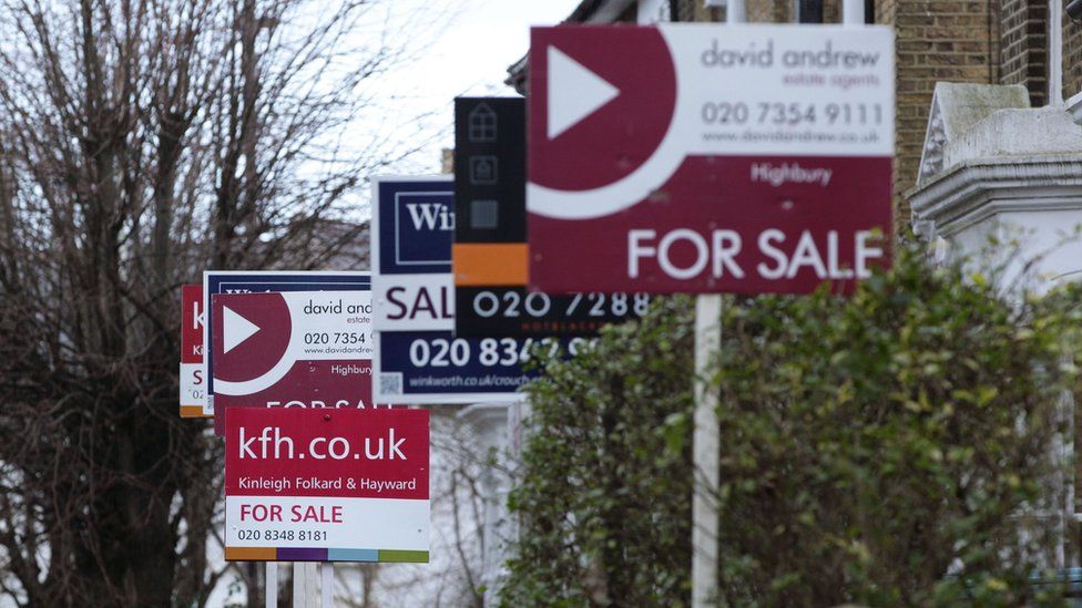 Estate agent signs outside houses