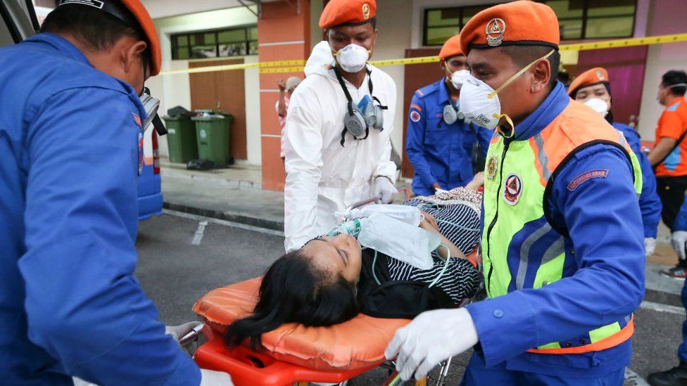 Emergency personnel evacuate a victim to a hospital after a toxic chemical spill in Pasir Gudang