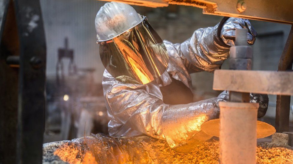 A metal worker wearing face protection