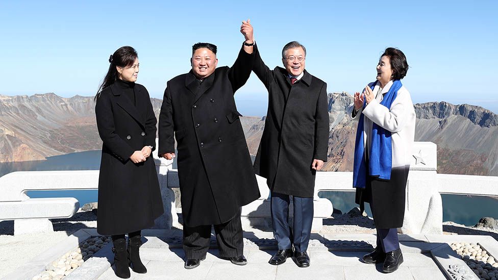 Северокорейский лидер Ким Чен Ын (2-й слева) и его жена Ри Сол Джу (слева) позируют с президентом Южной Кореи Мун Чжэ Ином (2-й справа) и его женой Ким Чжон Сук (справа) на вершине горы Пэкту в сентябре. 20 октября 2018 года на горе Пэкту, Северная Корея. (Фото Pyeongyang Press Corps/Pool/Getty Images)