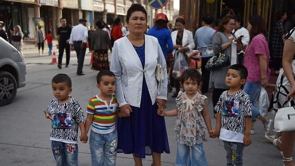 A Uighur woman waiting with children on a street in Kashgar in China's northwest Xinjiang region.