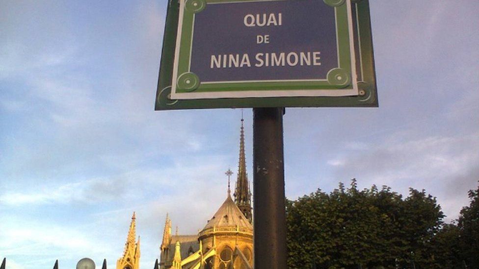 A street sign with Nina Simone's name in front of Notre Dame cathedral