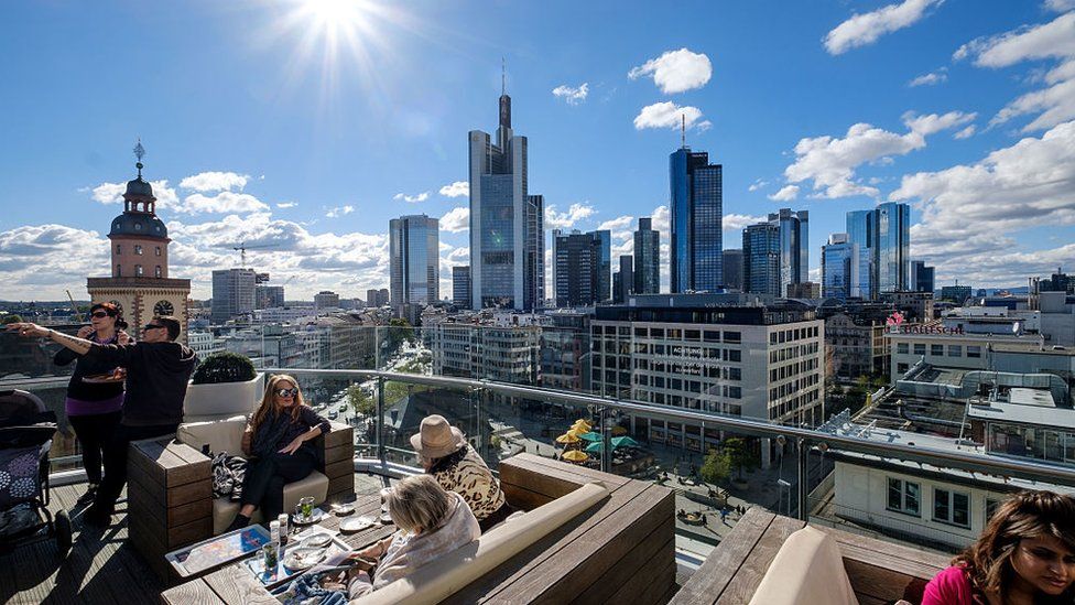People on roof top terrace against Frankfurt skyline