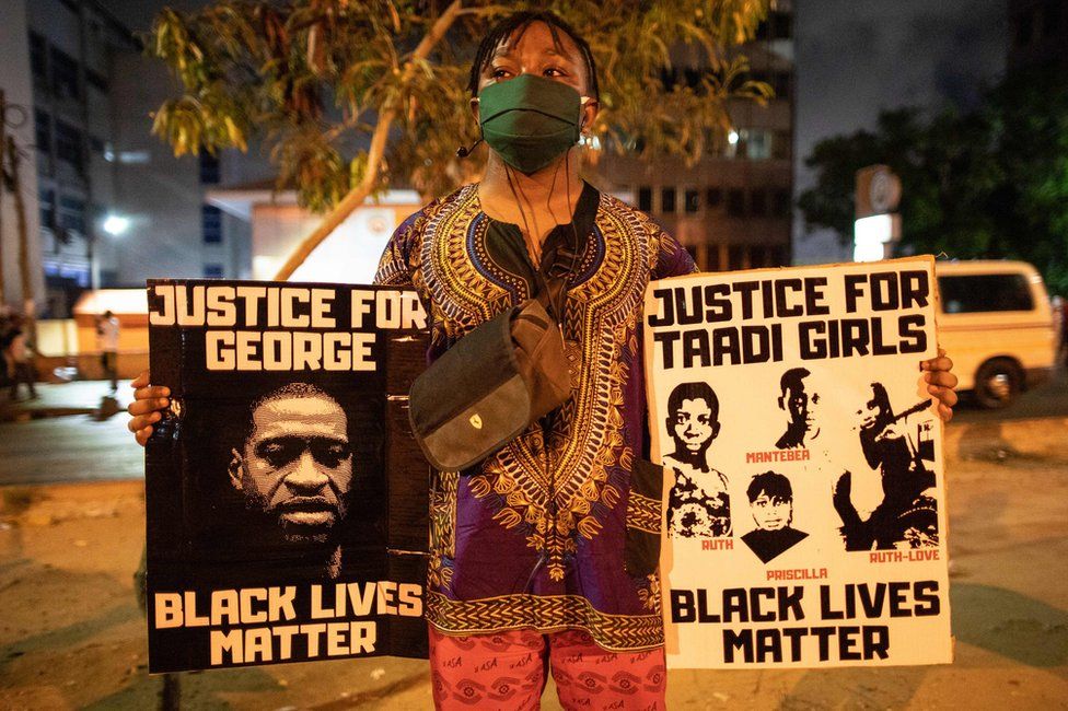 An activist holds placards in Accra, Ghana, during the protest.