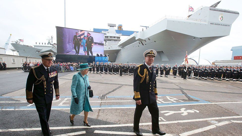 Queen Elizabeth II and the Duke of Edinburgh (left) arrive at HMS Queen Elizabeth in Rosyth Dockyard, Fife, where the Queen will formally name the Royal Navy's biggest ever ship, with whisky replacing the more traditional champagne at the ceremony.
