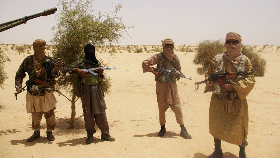 In this file photo from 24 April 2012, fighters from Islamist group Ansar Dine stand guard during a hostage handover in the desert outside Timbuktu, Mali.