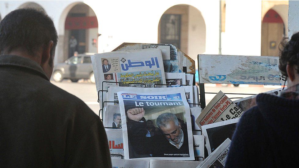 Марокканцы наблюдают в Рабате на первых полосах газет, посвященных победе Исламистской Партии справедливости и развития (PJD) - ноябрь 2011 г.