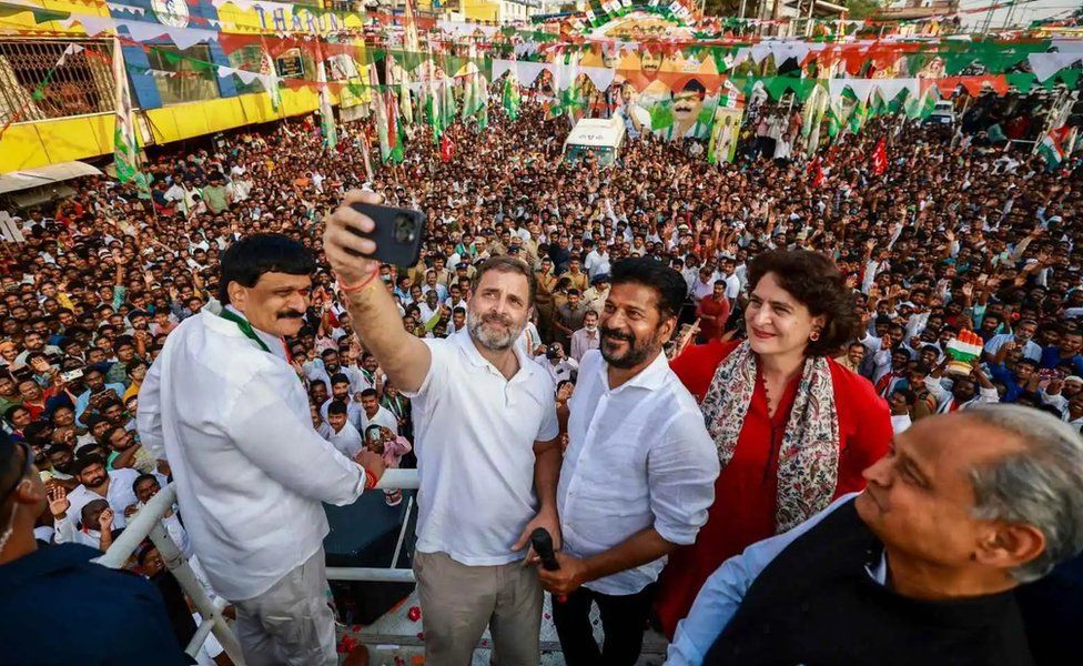 Congress leader Rahul Gandhi takes a selfie with party’s general secretary Priyanka Gandhi, state chief Revanth Reddy and Rajasthan CM Ashok Gehlot during a roadshow ahead of the Telangana Assembly elections, at Malkajgiri in Hyderabad, Tuesday, Nov. 28, 2023.