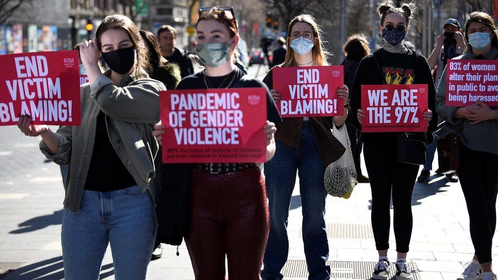 Women display signs to protest against violence