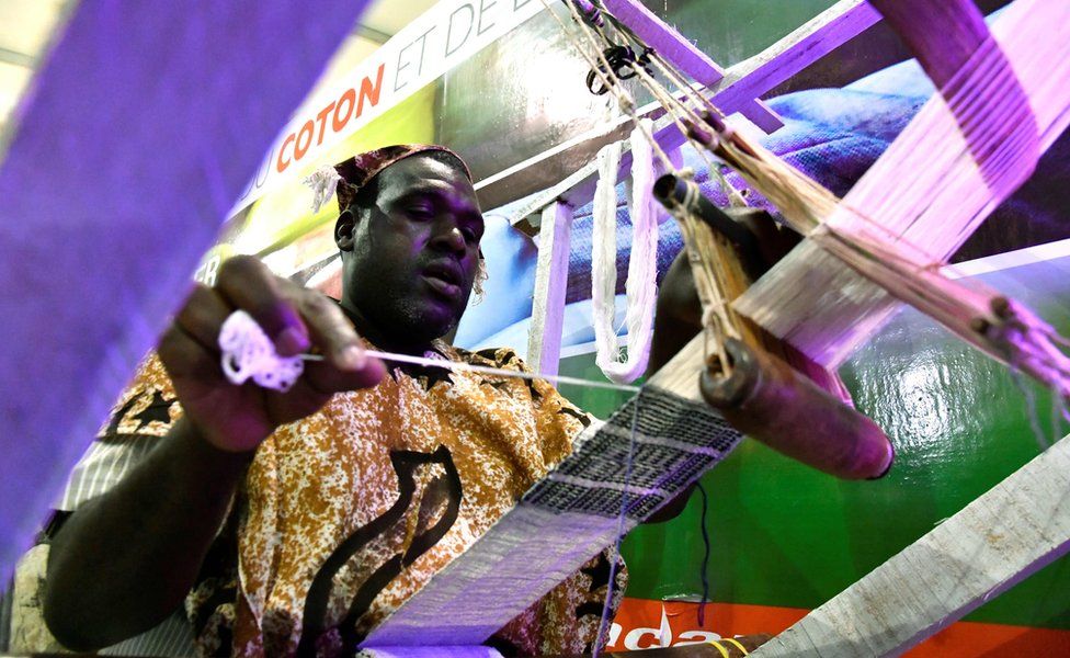 An weaver works on a loom at the opening of the fourth International Exhibition of Agriculture and Animal Resources (SARA 2017) in Abidjan on November 17, 2017